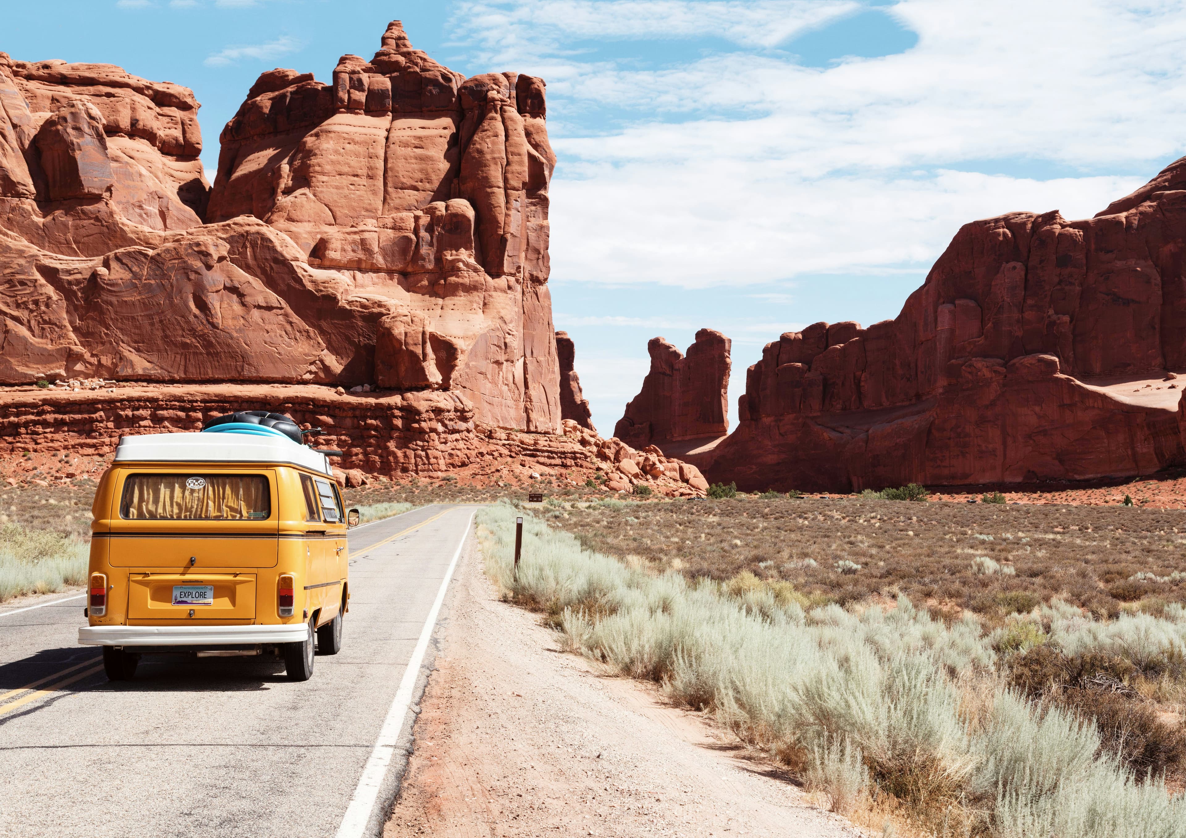 Yellow van driving through red rock canyons